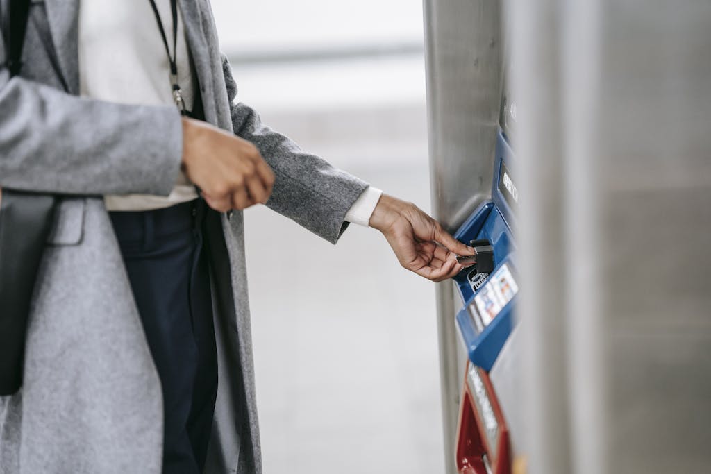 Faceless woman buying metro ticket via electronic machine