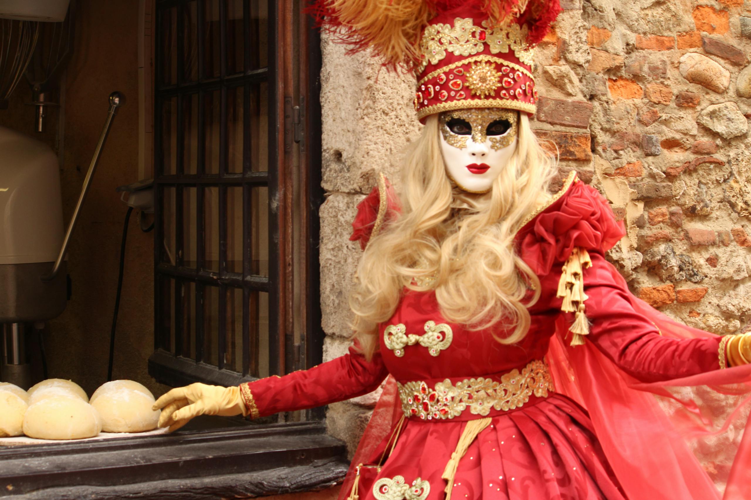 A woman in a red and gold costume with a mask