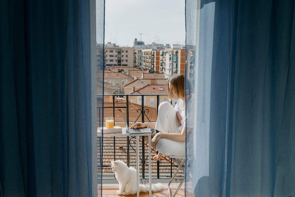 Woman in White Shirt Sitting on Chair Beside White Dog